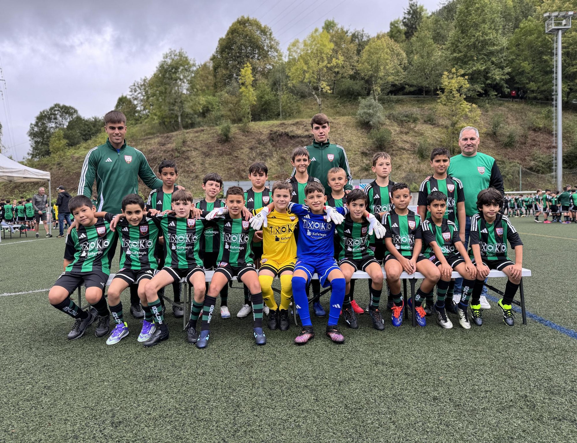 Futbol partida ugari Ezoziko futbol zelaian, tartean, futbol eskolakoen estreinaldia