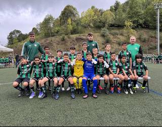 Futbol partida ugari Ezoziko futbol zelaian, tartean, futbol eskolakoen estreinaldia